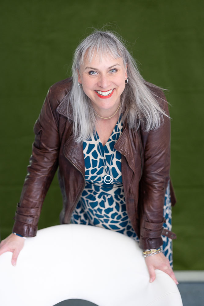 Freudestrahlendes Porträt einer Unternehmerin vor grünem Vorhang. Personal Brand Fotografie, Augsburg. Fotoshooting für Business Frauen Power Frauen, Business Frauen, Personalbrand