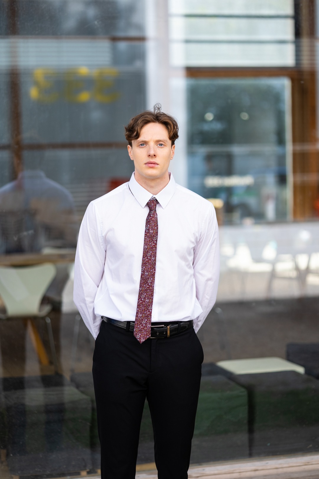 Professionelles Business Portrait eines lächelnden Mannes in weißem Hemd vor dunklem Hintergrund - Personal Brand Fotoshooting München