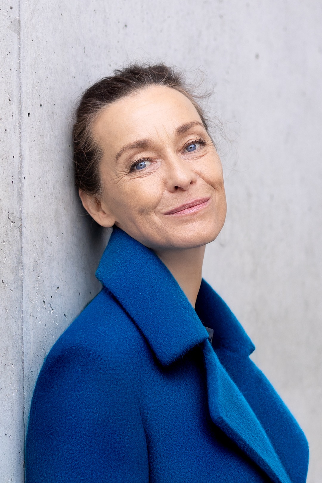 Business Shooting an der Pinakothek der modernen in München. Unternehmerin mit eleganten Blauen mantel.