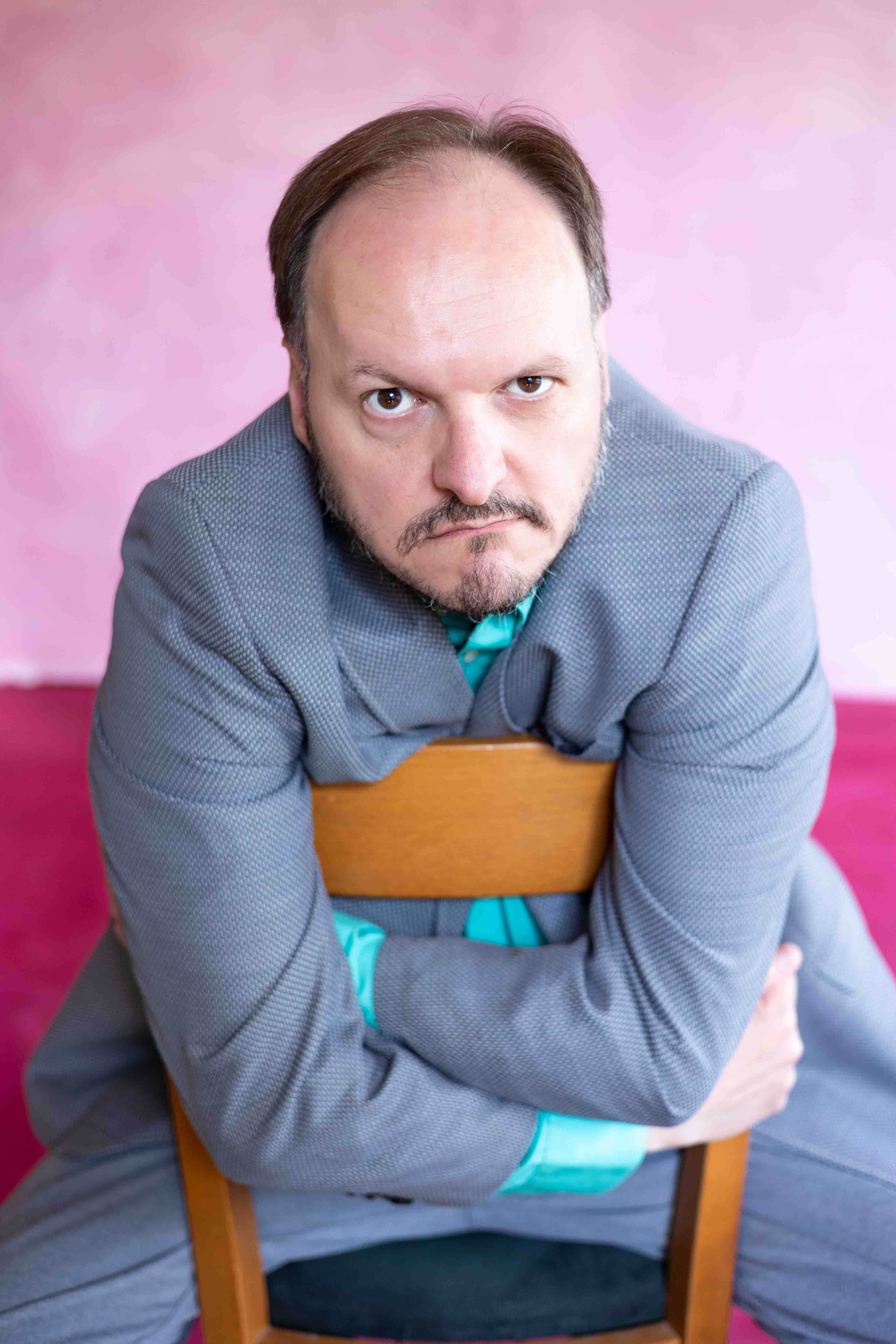 Schauspieler Mike Sobotka vor einer rosa Wand