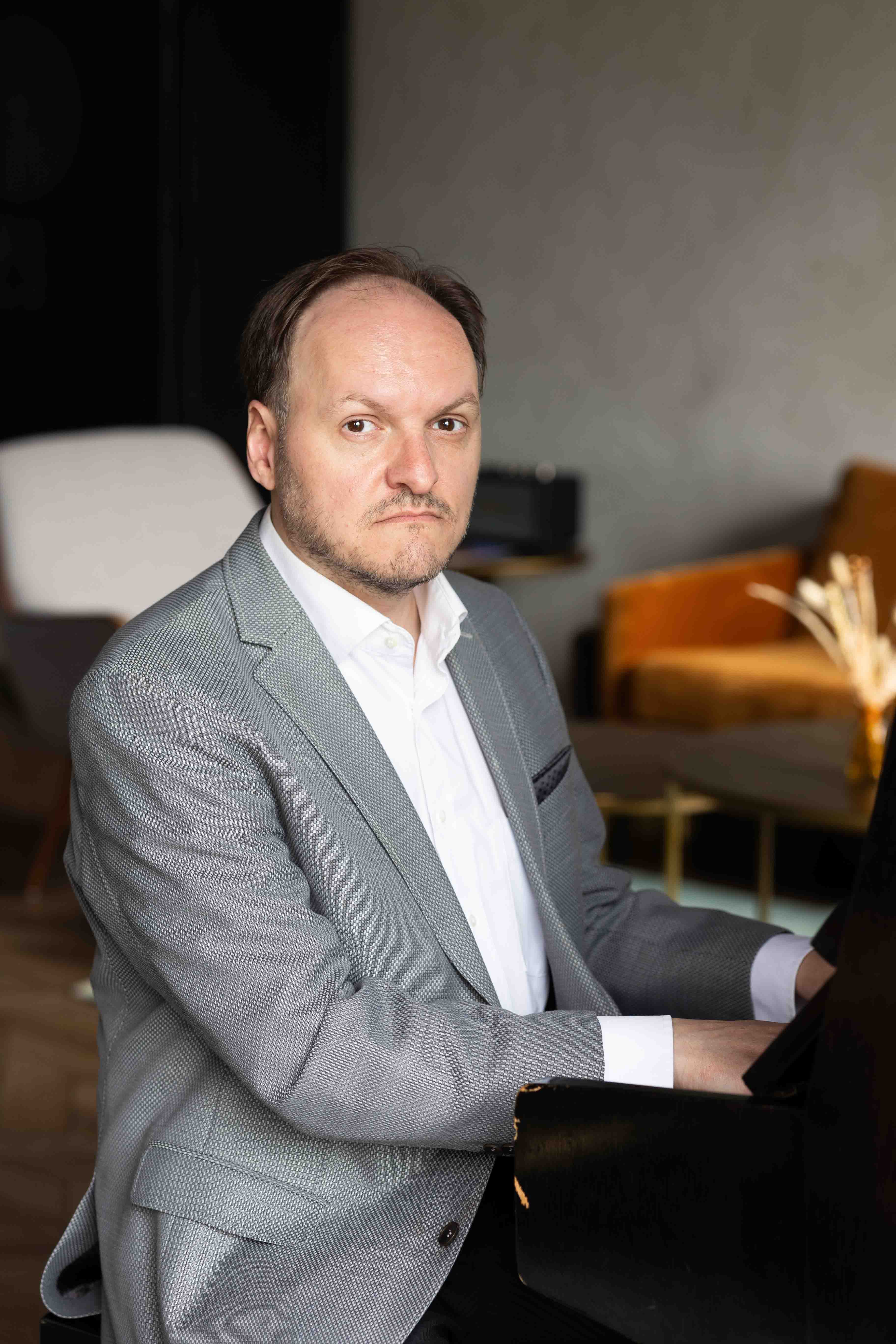 Schauspieler Mike Sobotka am Klavier sitzend